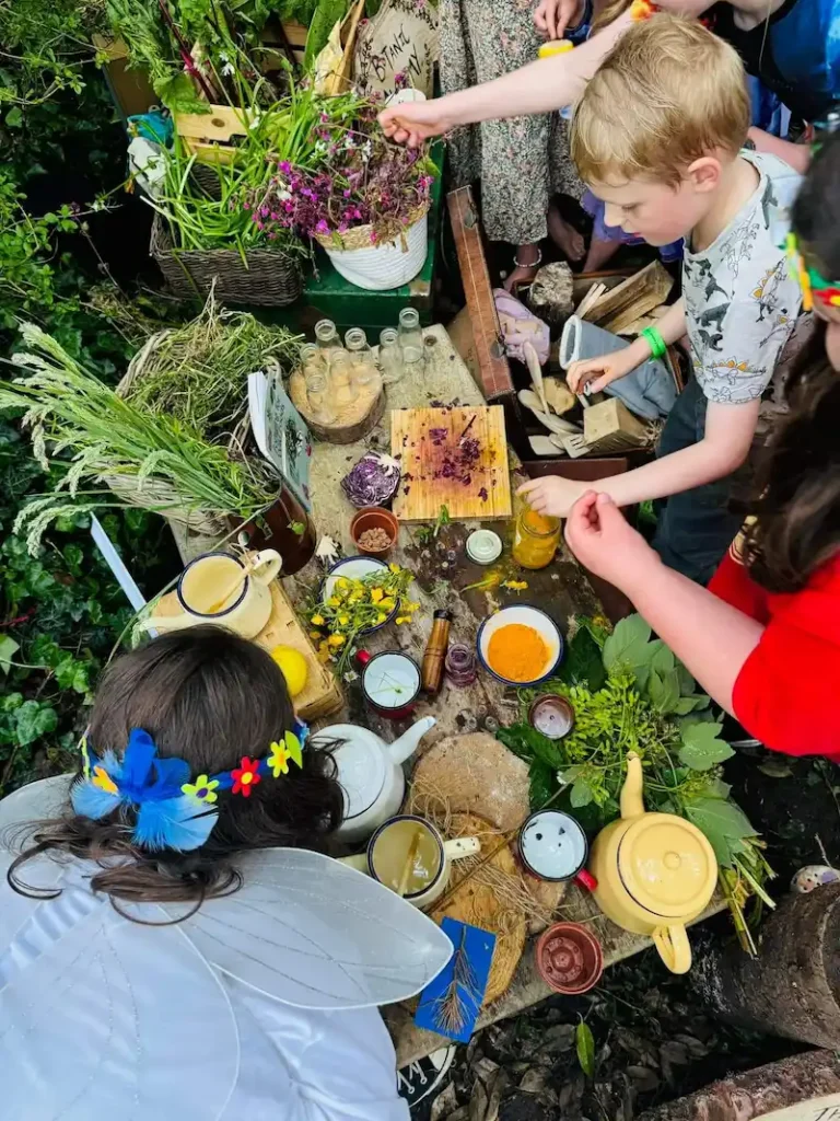 Children making potions at a forest school activity during a faerie festival in Plymouth